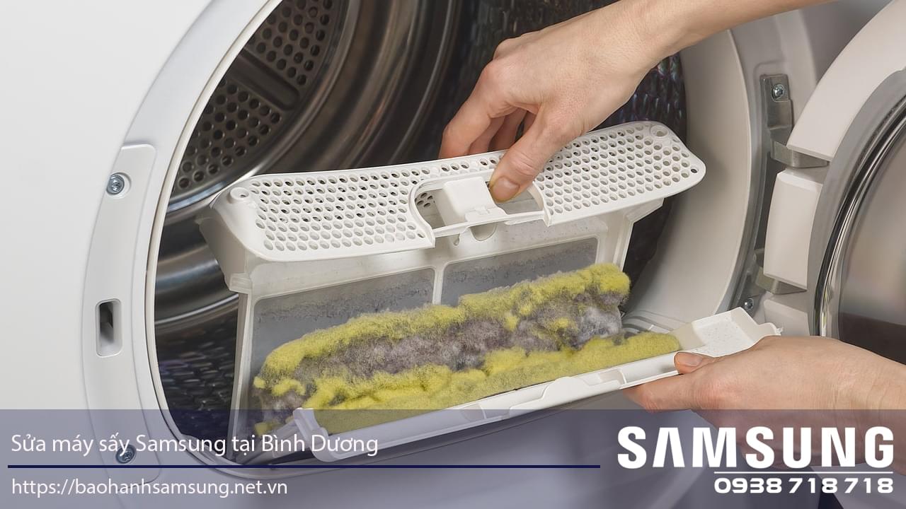 Spinning washing machine with technician replacing lint filter, Samsung washing machine repair service in Binh Duong, Vietnam.